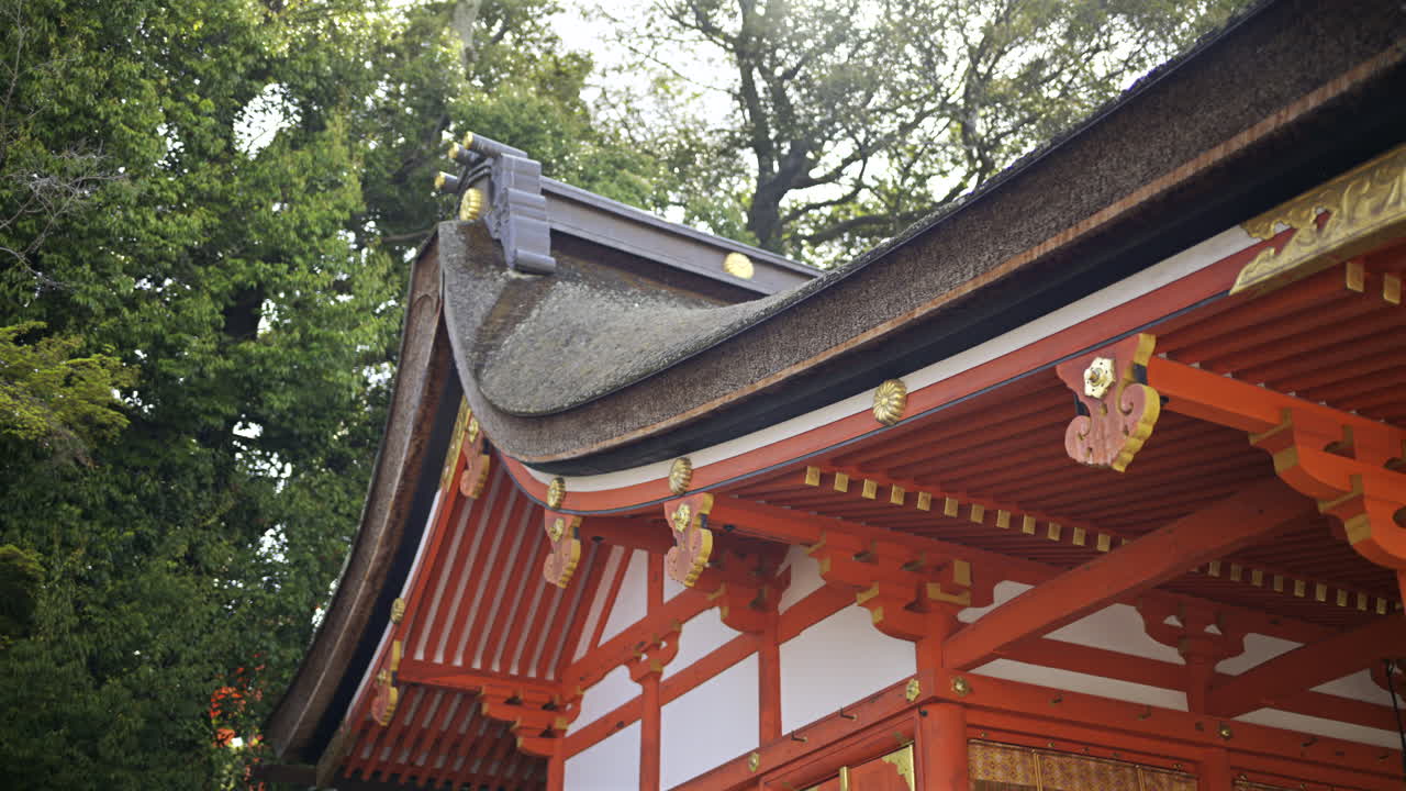 Traditional roof design features ornate elements and vibrant colors in Fushimi Inari shrine garden. Kyoto, Japan