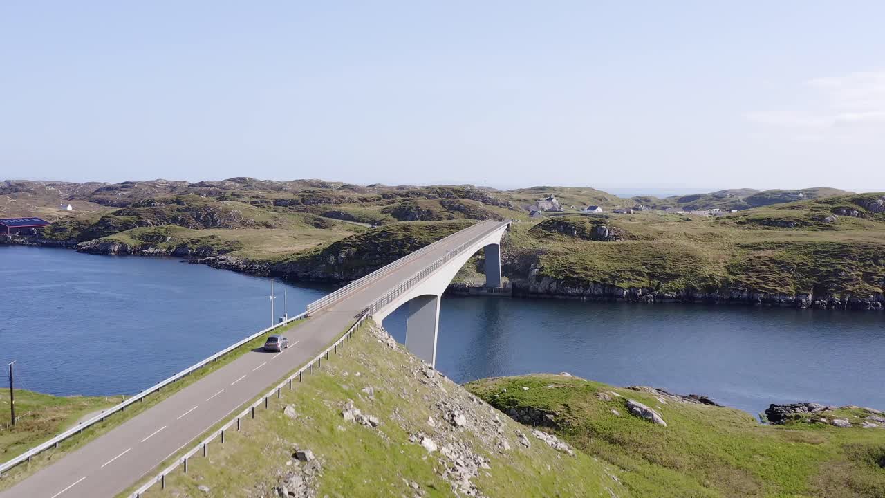 스코틀랜드 외부 헤브리드 섬의 해리스 섬 근처의 스칼페이 섬 다리를 가로지르는 차를 추적하는 드론  ⁇