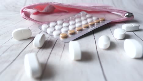 pink pouch with birth control pills and other medications
