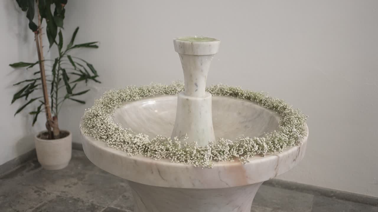 Elegant marble baptism font adorned with delicate white floral ring