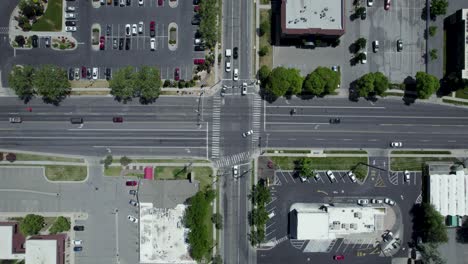 commuter traffic from cars driving through city street intersection - overhead bird's eye aerial view