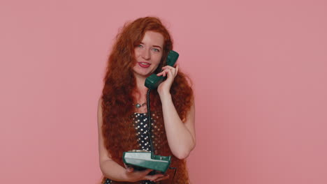 Cheerful-red-hair-girl-secretary-talking-on-wired-vintage-telephone-of-80s,-say-hey-you-call-me-back