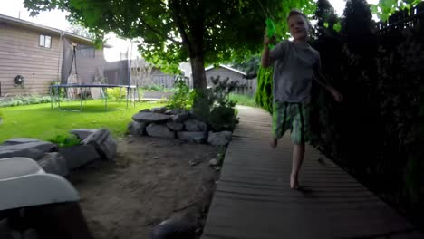 Boy-running-on-board-walk-and-playing-with-water-gun-4k