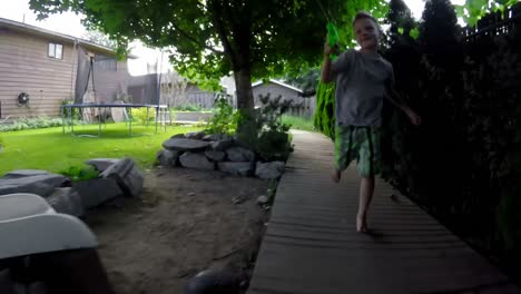 niño corriendo a bordo caminando y jugando con una pistola de agua 4k