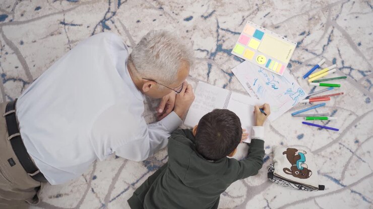 Father and son draw pictures and do homework at home.