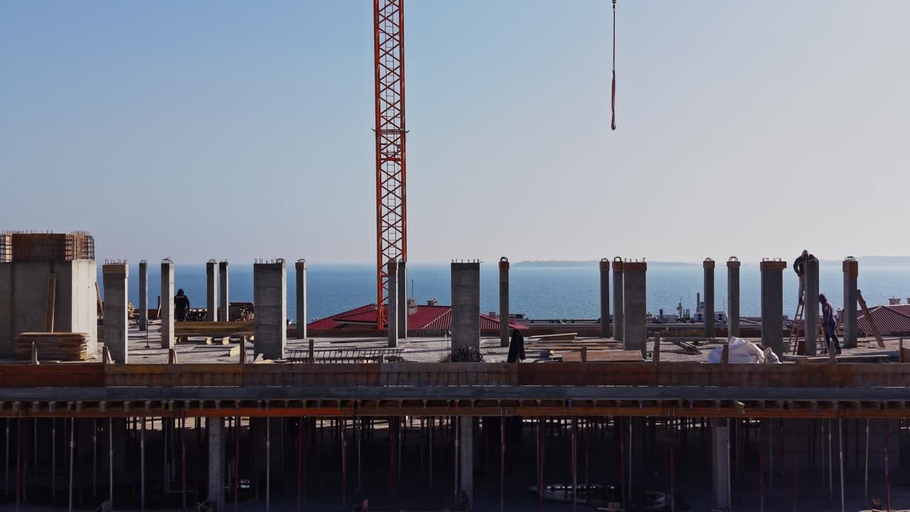 Construction Workers on Rooftop of Building with Ocean View