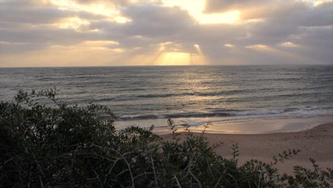 playa océano con hora dorada sol detrás de la nube día ventoso