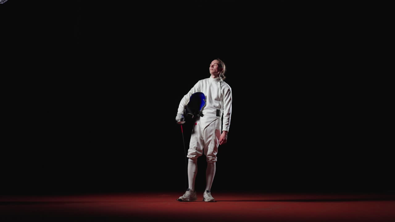 검과 마스크를 입고 색 의상을 입은 젊은 남자 펜싱 선수