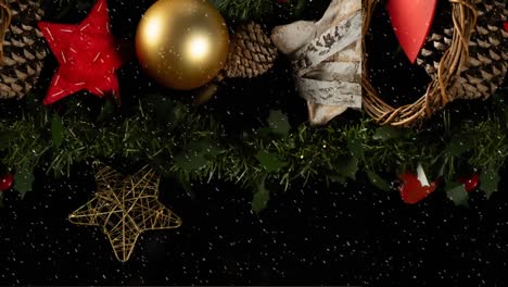 animation of christmas decoration and snow falling on black background