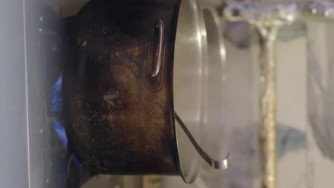 pot on a stove with a blue flame