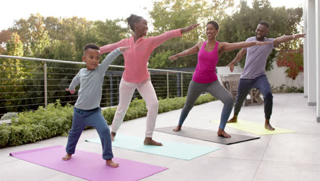 happy african american parents, son and daughter practicing yoga in sunny garden, in slow motion