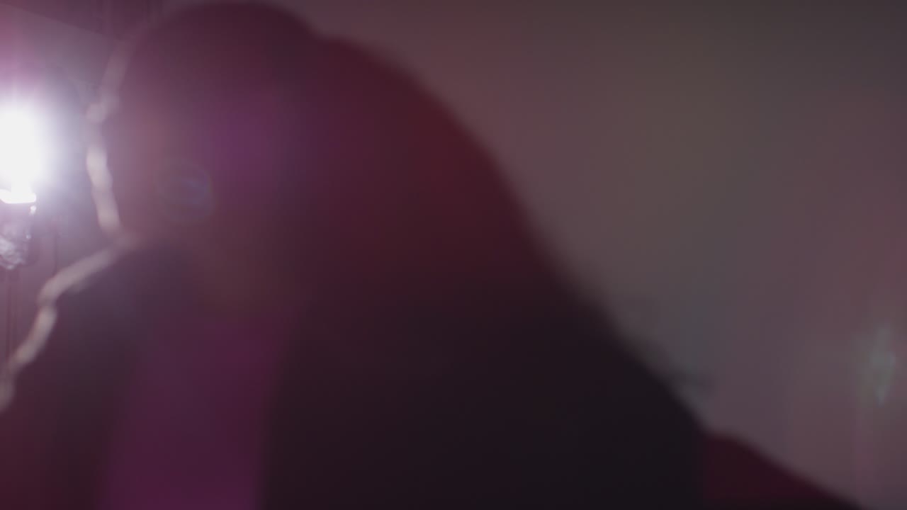 Defocused Backlit Studio Shot Of Casually Dressed Young Woman Dancer Dancing In Spotlight