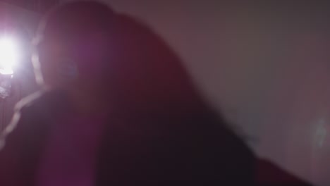 disparo de estudio retroiluminado desenfocado de una bailarina joven vestida casualmente bailando en el centro de atención