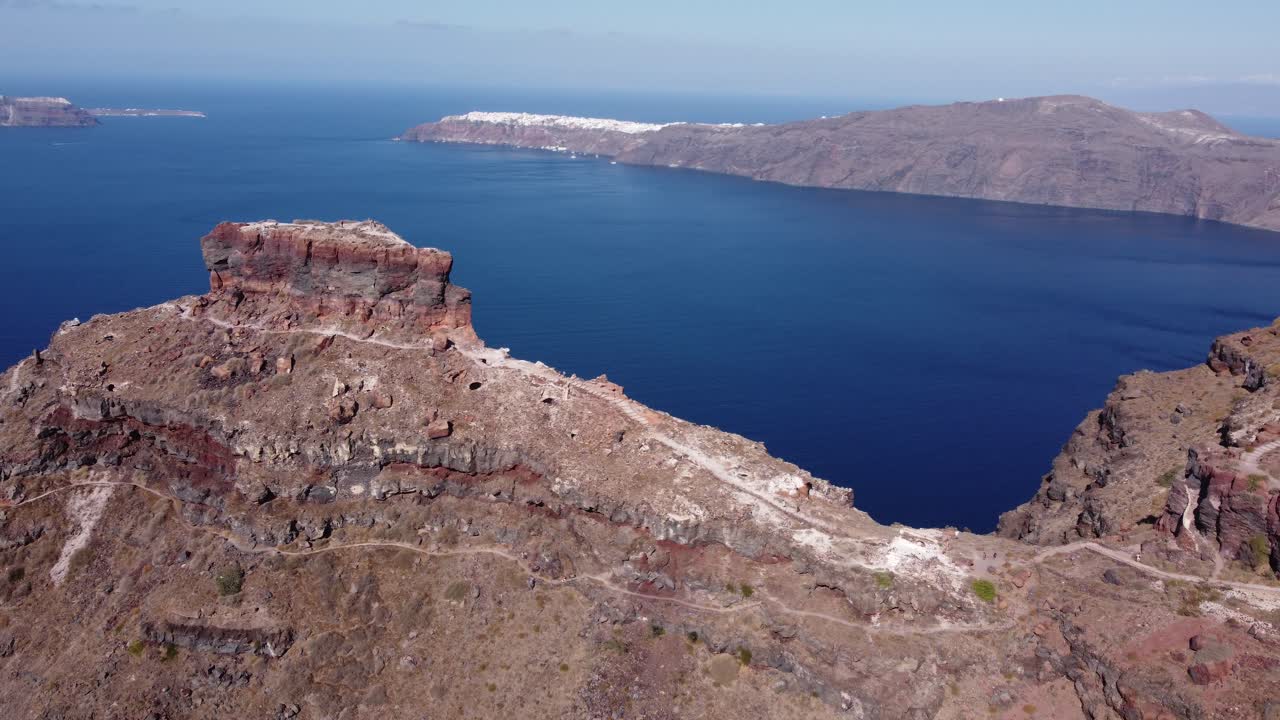 imágenes aéreas de drones volando sobre la roca skaros para revelar un paisaje dramático, imerovigli santorini