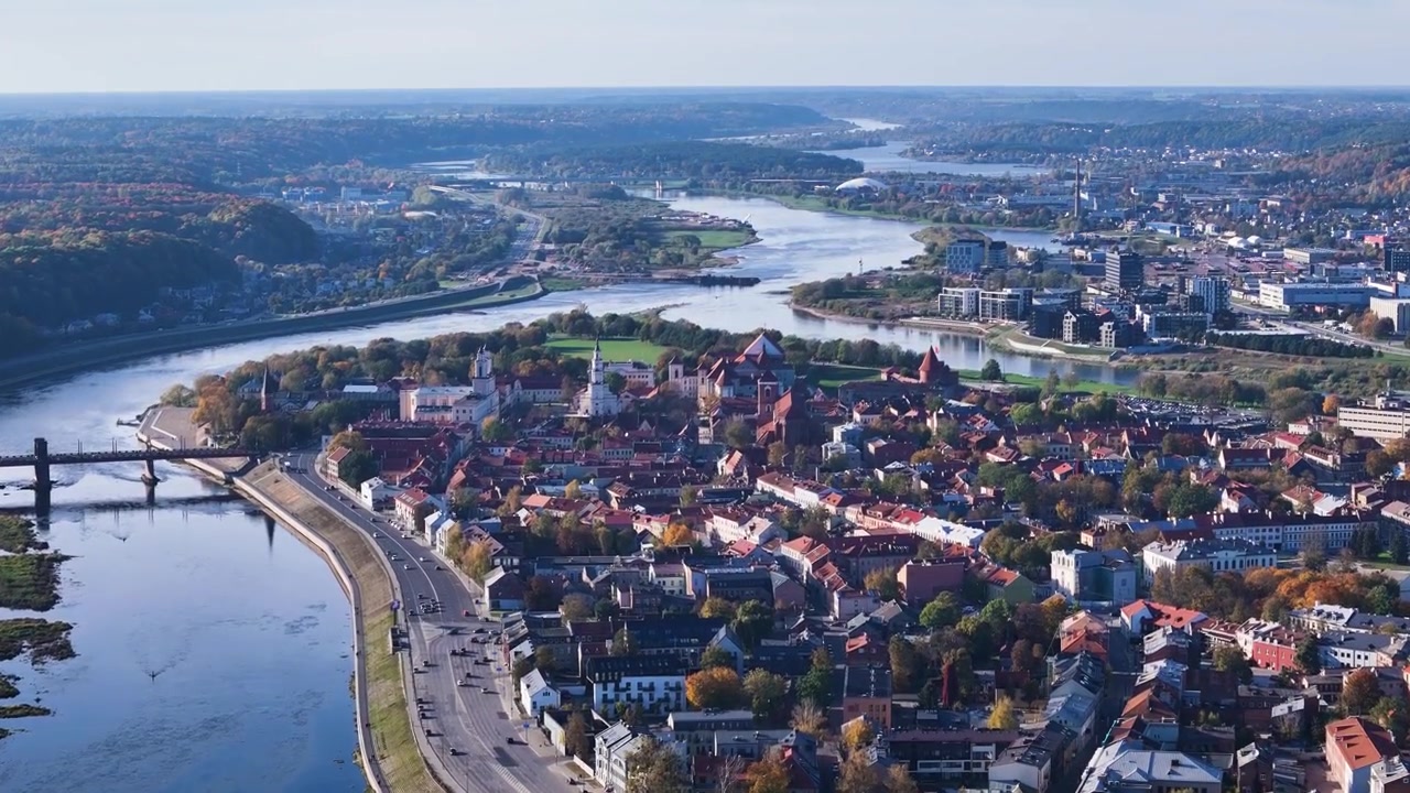 Ampia veduta aerea della città vecchia di Kaunas con la confluenza dei fiumi Neris e Nemunas, castello, chiese e fogliame autunnale colorato, Lituania, ripresa ascendente con drone