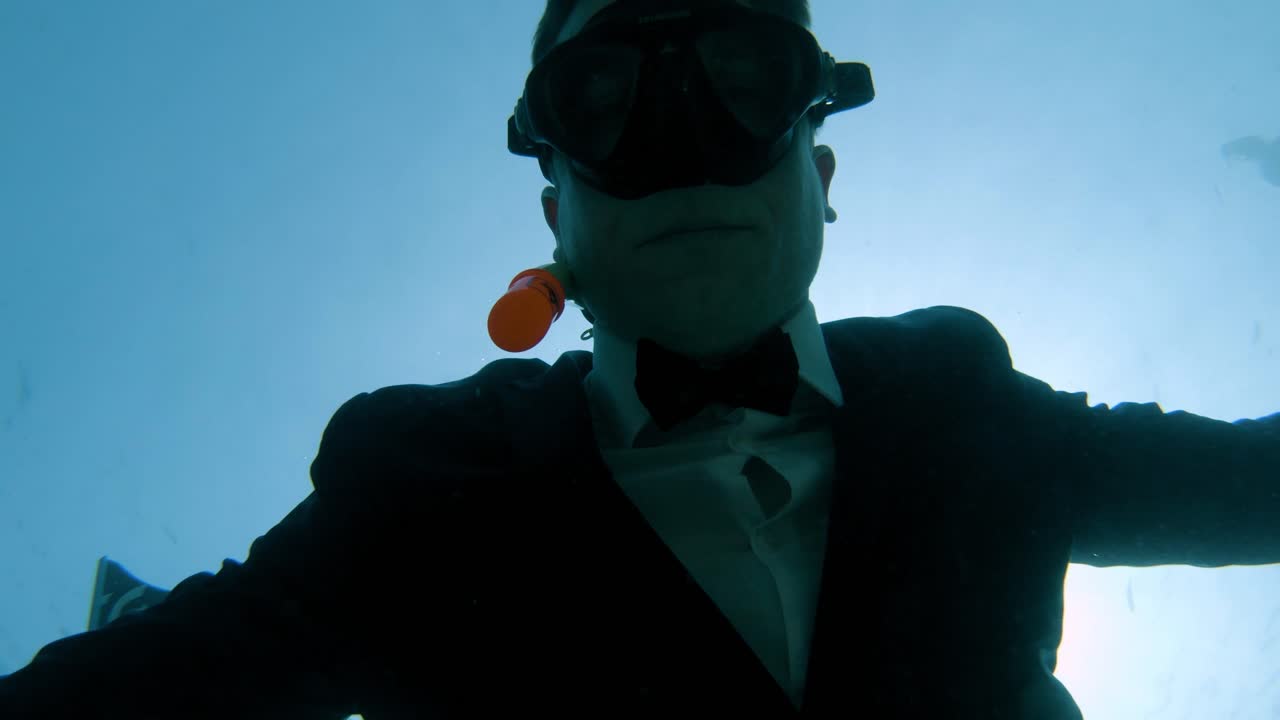 freediver in business suit swims up to the surface