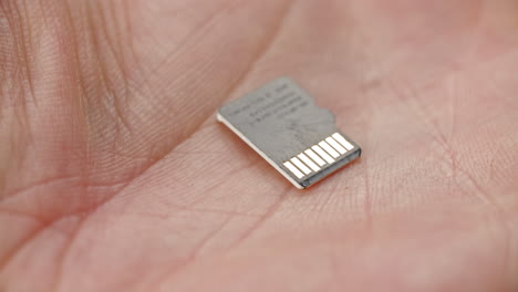 tiny mirco sd card on palm of a hand, memory, data storage, compact size technology advancement