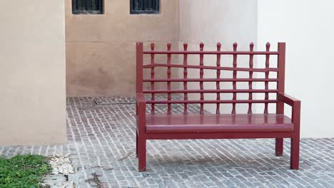 red wooden bench in an alleyway