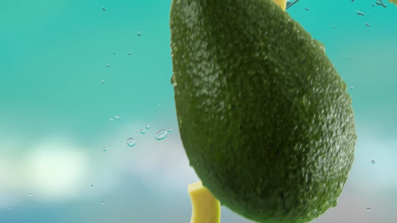 aguacate con rebanadas y salpicaduras cayendo en el fondo de la playa