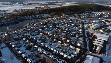 Panorámica-Aérea-De-Alto-ángulo-A-Través-De-Una-Pequeña-Ciudad-Suburbana-Escandinava-Con-Techos-Cubiertos-De-Nieve.