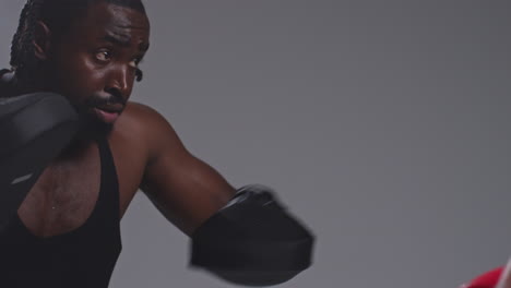 Close-Up-Shot-Of-Male-Boxer-Sparring-Working-Out-With-Trainer-Wearing-Punch-Mitts-Or-Gloves-Practising-For-Fight-6