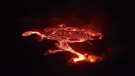 aerial wide view of an erupting volcano at night