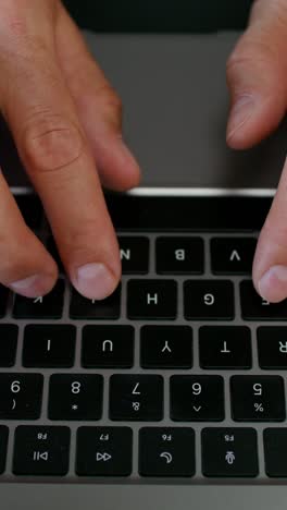 hands typing on a laptop keyboard