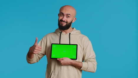 arab guy holding device with greenscreen blank display