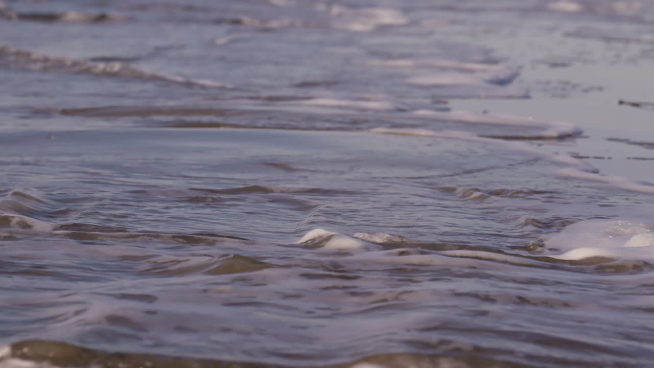Sea waves rushing at the beach during sunset