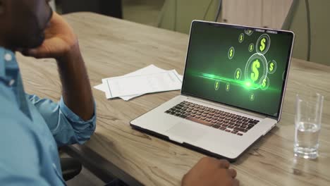 video de un hombre afroamericano trabajando en una computadora portátil con dólares criptográficos en la pantalla