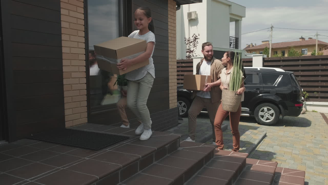 Famiglia di quattro persone che trasporta i propri effetti personali e trasloca