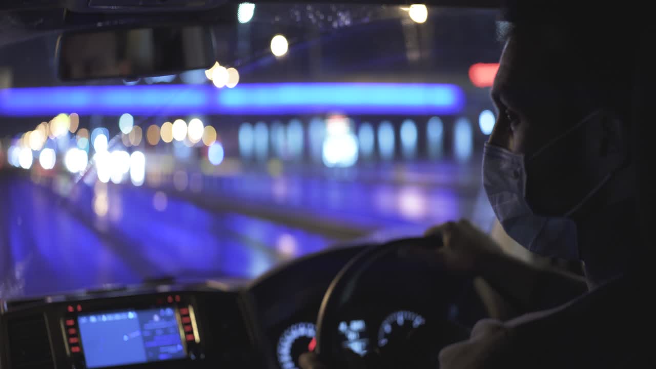 의료 마스크를 입은 젊은 남자가 밤의 도시 도로를 달리고 있습니다.