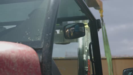 close up of a man driving a forklift and pointing at somethin as he drives towards it afterwards