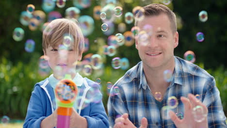 Vater-Und-Sohn-Blasen-Gemeinsam-Seifenblasen-Im-Sonnigen-Park.-Glücklicher-Kleiner-Junge,-Der-Spaß-Hat.-Vater-Spielt-Mit-Kind-Und-Genießt-Spielerisch-Den-Sommer-4k