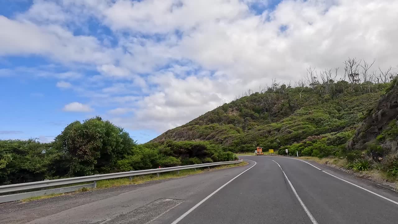 A 15-second video captures a serene drive along the Great Ocean Road, showcasing coastal views and lush greenery under a bright sky