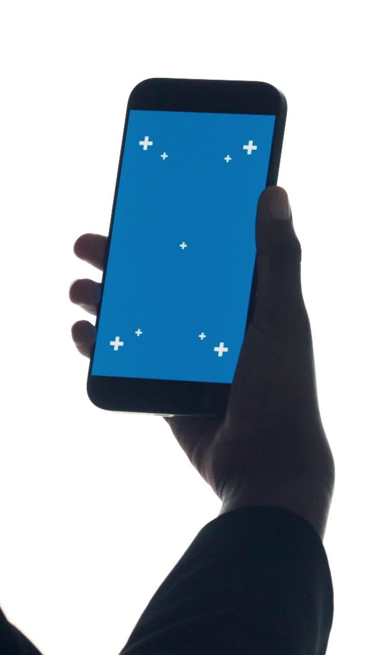 Silhouette di una mano che tiene uno smartphone con schermo blu e marcatori di tracciamento