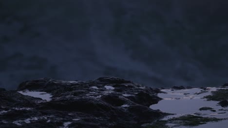 extreme close-up: ocean spray crashes down on rocky tide pool. filmed at sunset on the oregon coast.