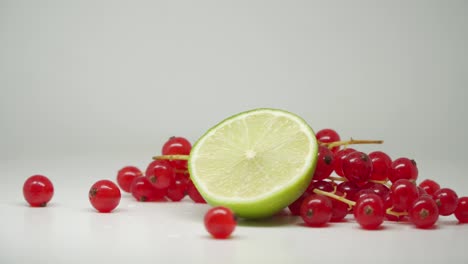 fresh red currant and slice lime fruit at the top of the turntable - close up shot