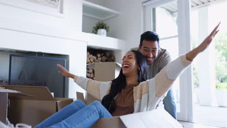 couple, moving and fun at home with cardboard box