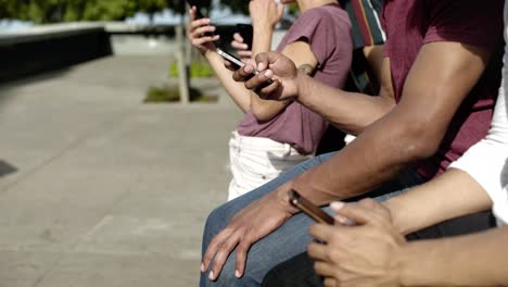 side view of people using digital devices on street