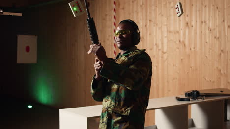 portrait of cheerful soldier doing training in shooting range, reloading rifle