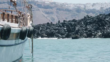 Fishing-boat,-vessel,-tires,-ropes,-docked,-floating,-rocking,-ocean,-sea,-cliff,-Oia,-close-up,-Santorini,-Islands,-Greece