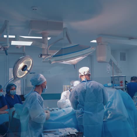 group of doctors perform an operation to a patient. surgeons in medical uniform and masks working in the operating room.