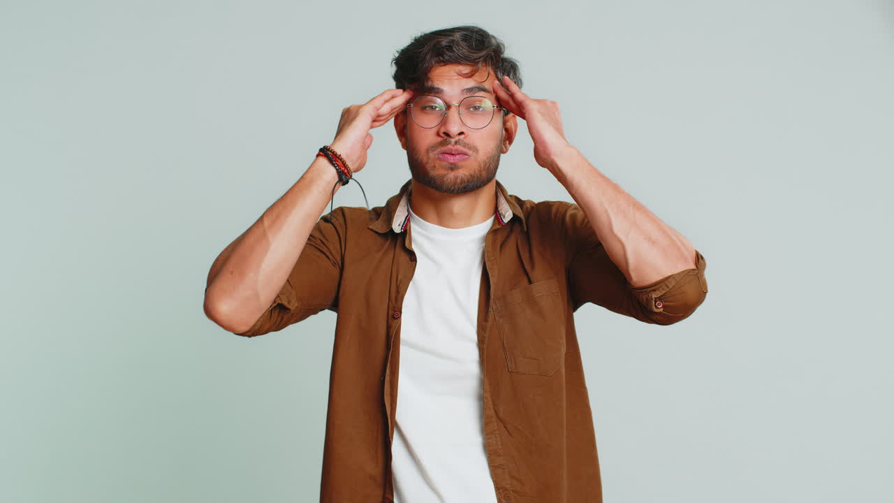 hombre indio frotando las sienes para curar el dolor de cabeza problema, sufriendo de tensión y migraña dolor de estrés