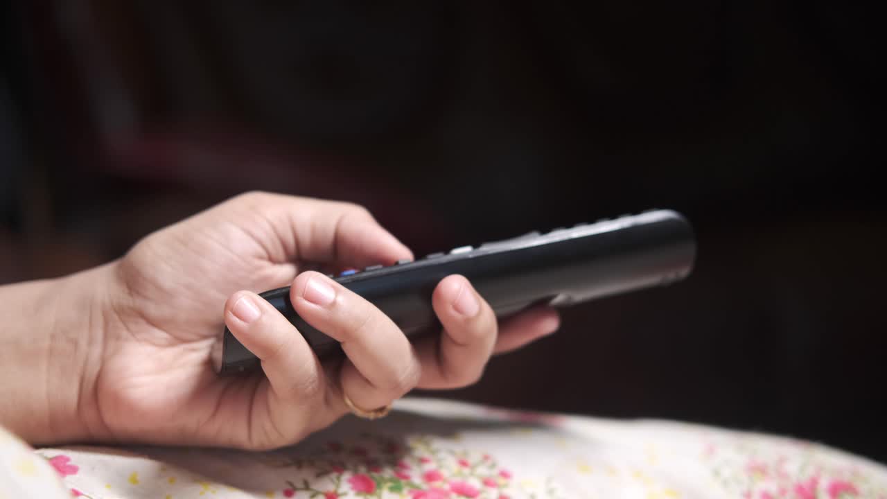 tv 리모컨 을 들고 있는 손