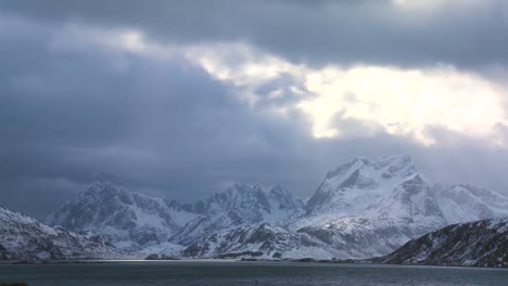 Heavenly-light-streams-down-on-a-beautiful-snow-covered-shoreline-amidst-fjords-north-of-the-Arctic-Circle-in-Lofoten-Islands-Norway-2