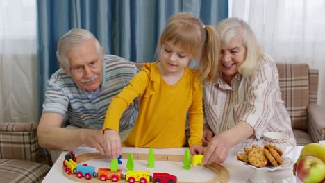 Pareja-Madura,-Abuela,-Abuelo-Con-Niña-Nieta-Montando-Un-Tren-De-Juguete-En-El-Ferrocarril-En-Casa