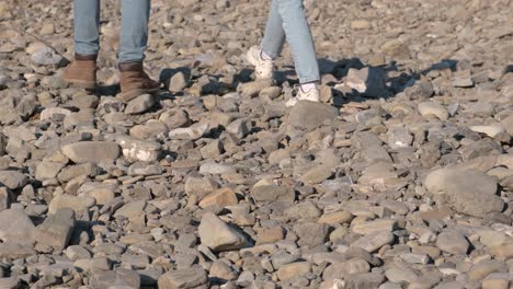 couples feet in shoes walking pebble stones. romantic couple walking on a beach