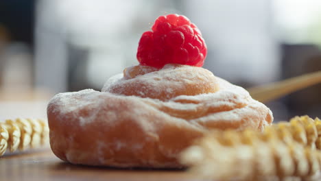 Wheat-bun-with-fresh-raspberry-on-the-table