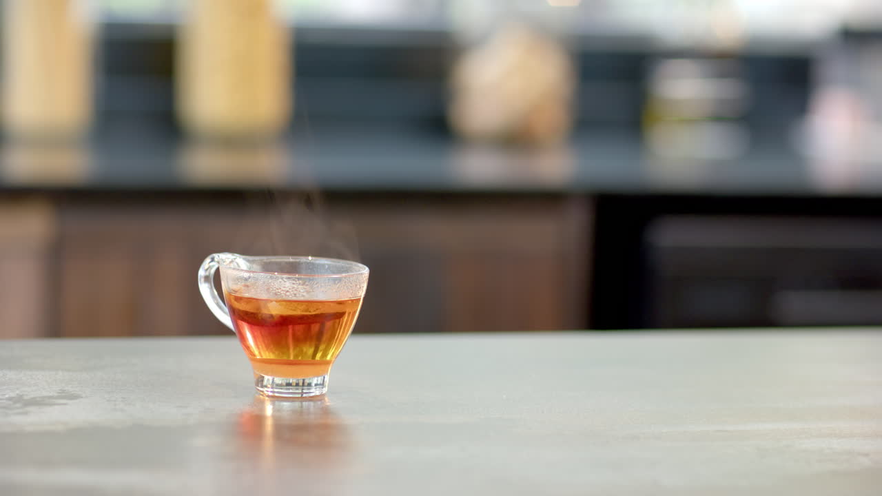 Steaming cup of tea on kitchen counter, creating cozy atmosphere, copy space